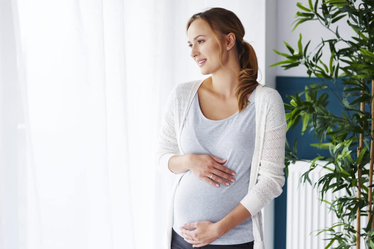pregnant woman looking through window